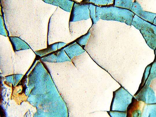 nicole gesmondi fine art photography peeling paint Blue-White Close-up of cracked, peeling paint in blue and white, showing an irregular, fragmented surface pattern.
