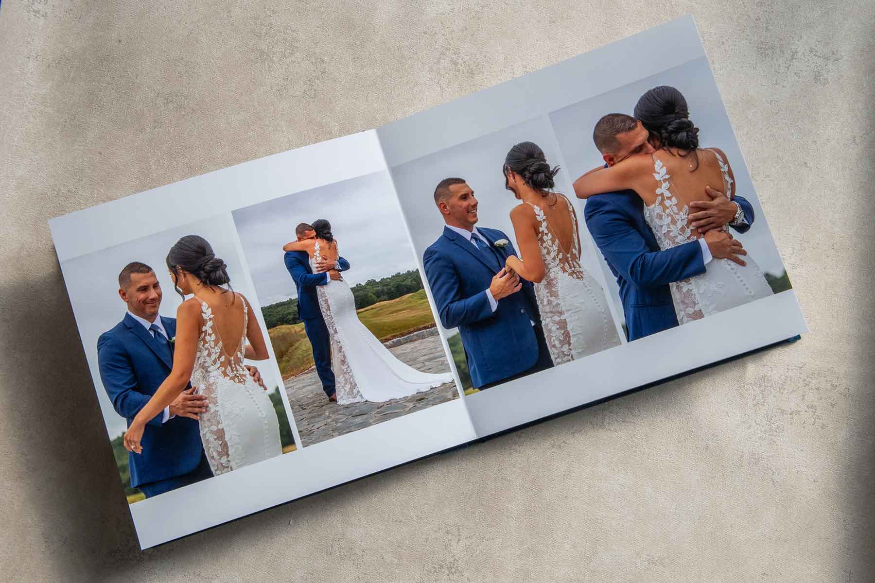 An open photo album displays images of a bride and groom outdoors, embracing and smiling at each other on their wedding day.