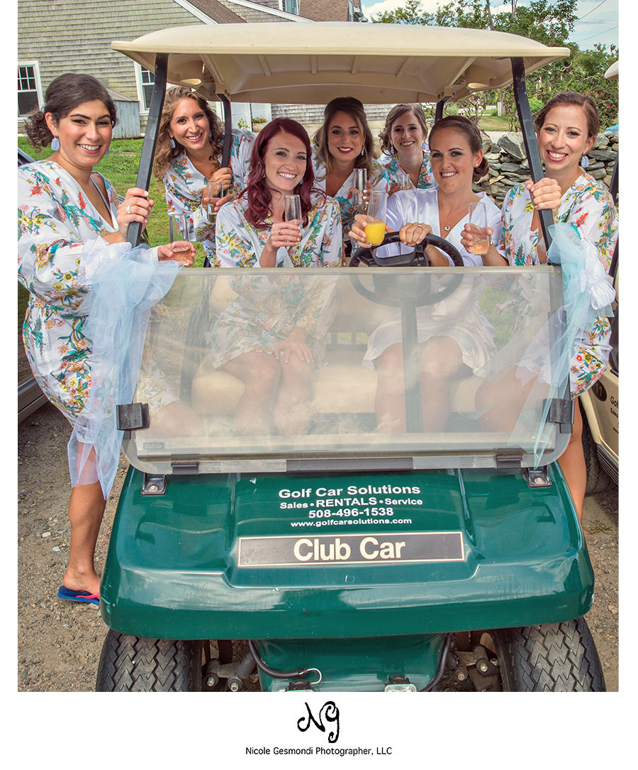 Bride with bridesmaids wearing matching robes and drinking champagne on a golf cart Bride with bridesmaids wearing matching robes and drinking champagne on a golf cart