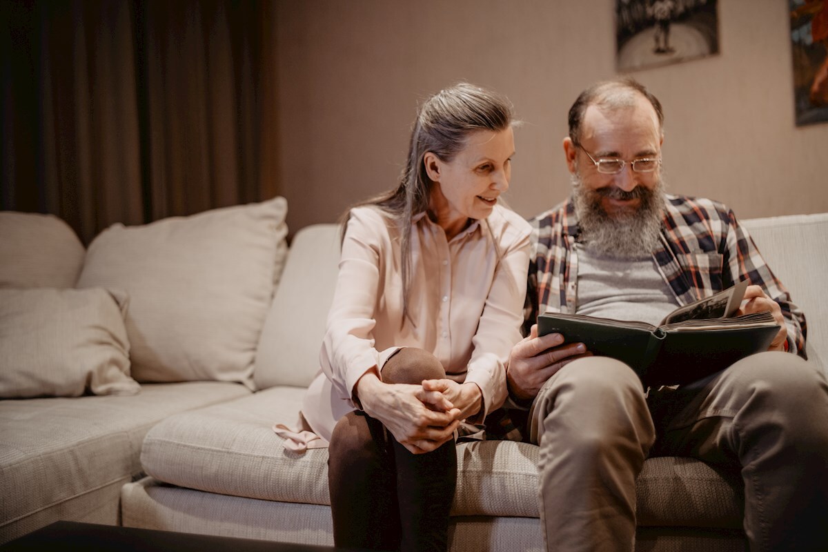 Elderly couple looking through a wedding album. Photo by Mikhail Nilov on Pixels.com