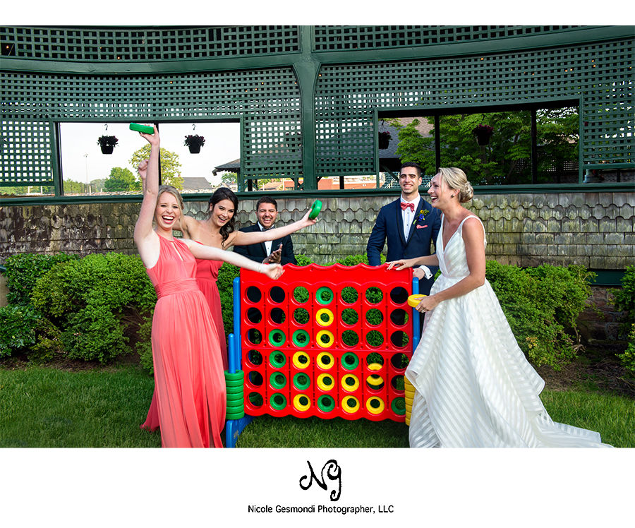 bride and wedding party playing giant Jenga at Tennis Hall of Fame in Newport RI bride and wedding party playing giant Jenga at Tennis Hall of Fame in Newport RI