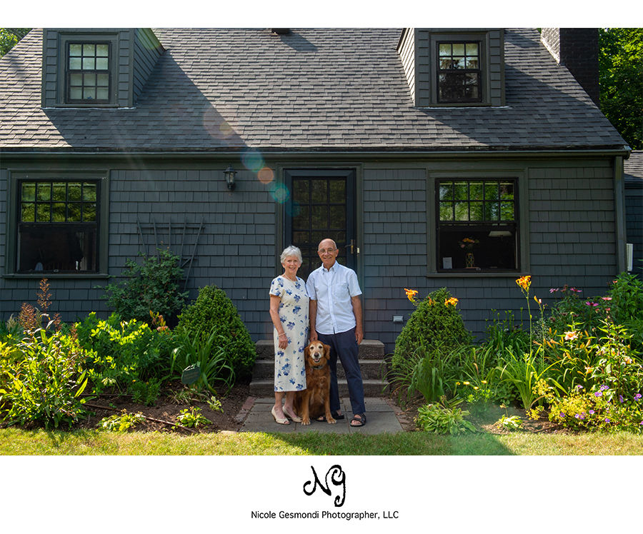 elderly husband and wife standing in front of their home in Barrington RI