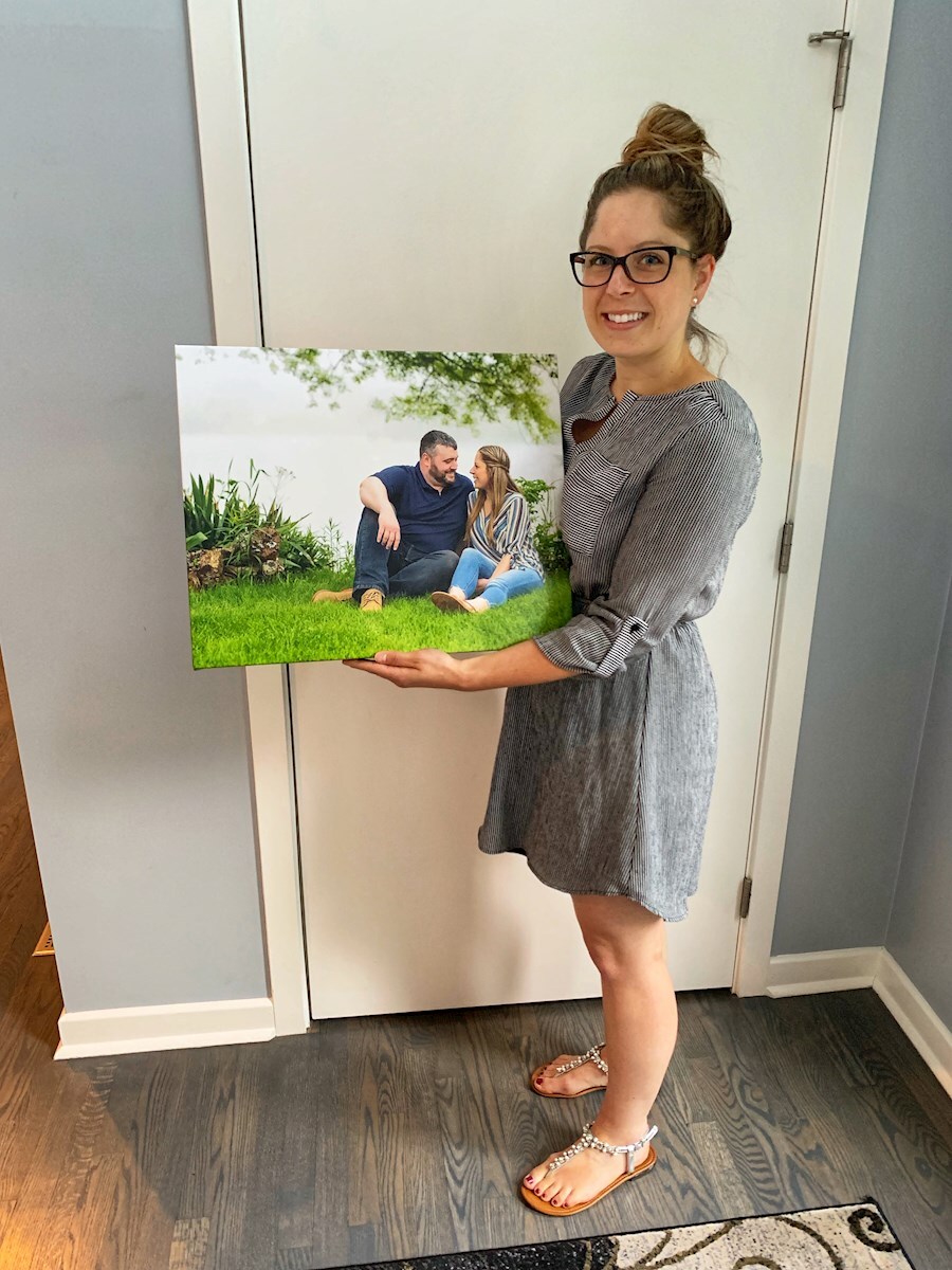 Client holding a canvas wrap they just ordered
