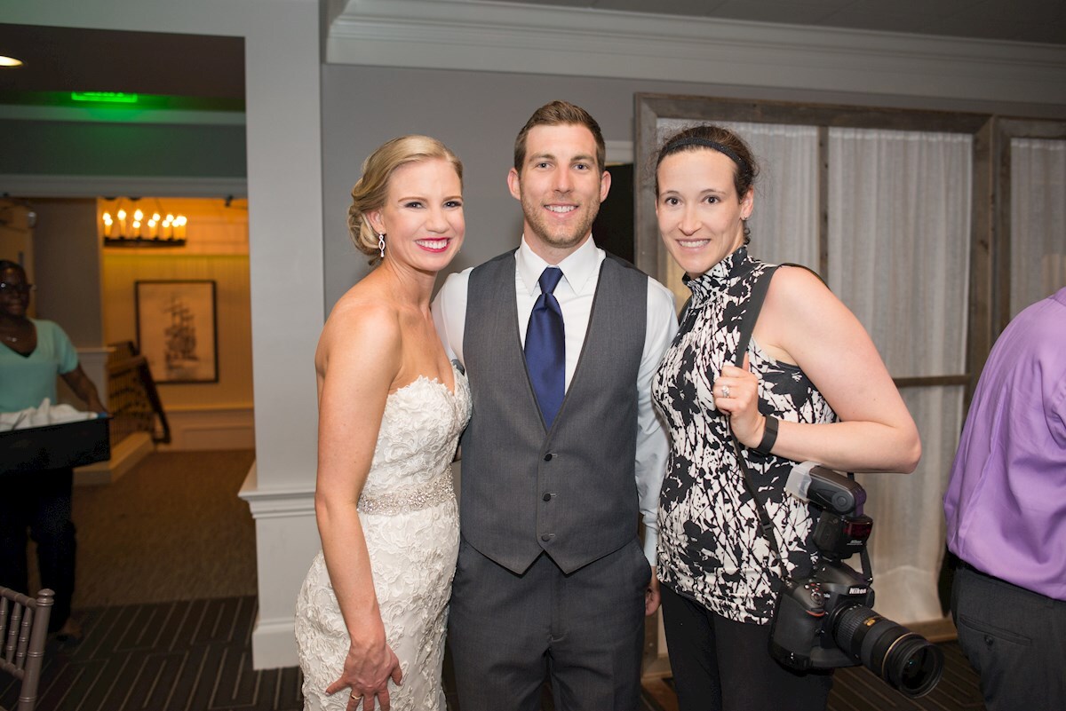 A photo of Kelly, Brandon and I during their wedding reception a photo of the bride and groom with their wedding photographer